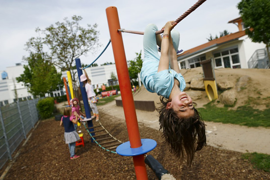 Children play in the garden of their kindergarten run by a private foundation which is not affected by the nursery caretakers' strike in Hanau, 30km south of Frankfurt, Germany, May 11, 2015. Most of the kindergartens run by public services all over Germany face a strike of the nursery caretakers as they fight for higher wages and better working conditions. REUTERS/Kai Pfaffenbach - RTX1CG3R
